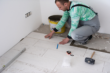 Image showing worker installing the ceramic wood effect tiles on the floor