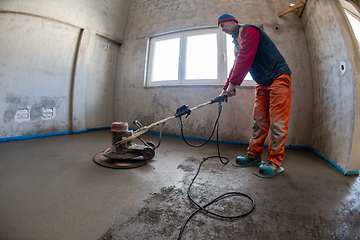 Image showing worker performing and polishing sand and cement screed floor