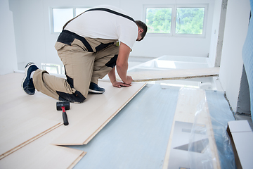 Image showing Worker Installing New Laminated Wooden Floor