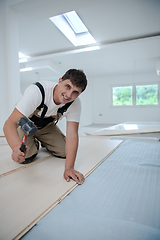 Image showing Professional Worker Installing New Laminated Wooden Floor