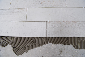 Image showing Ceramic wood effect tiles and tools for tiler on the floor