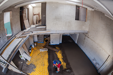 Image showing worker performing and polishing sand and cement screed floor