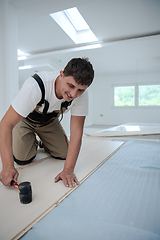 Image showing Professional Worker Installing New Laminated Wooden Floor