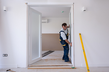 Image showing carpenters installing glass door with a wooden frame