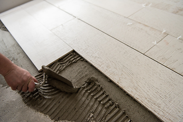 Image showing worker installing the ceramic wood effect tiles on the floor