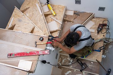 Image showing carpenter installing wooden stairs