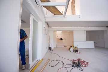 Image showing carpenters installing glass door with a wooden frame