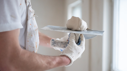 Image showing construction worker plastering on gypsum walls