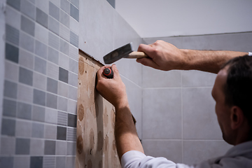 Image showing worker remove demolish old tiles in a bathroom