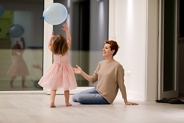 Image showing mother and cute little daughter playing with balloons