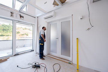 Image showing carpenters installing glass door with a wooden frame