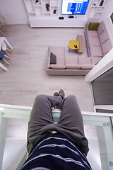 Image showing man sitting upstairs on glass floor