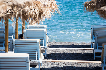 Image showing beach with umbrellas and deck chairs by the sea in Santorini