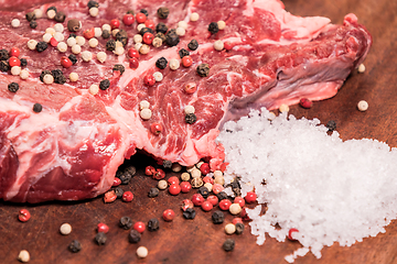 Image showing steak of beef on a wooden board with spices pepper parsley salt 