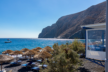 Image showing beach with umbrellas and deck chairs by the sea in Santorini