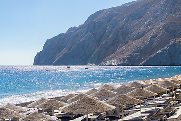 Image showing beach with umbrellas and deck chairs by the sea in Santorini