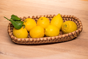 Image showing yellow lemons in a small wooden basket