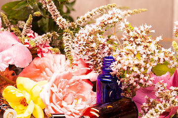 Image showing flowers and bottles of essential oils for aromatherapy