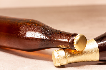 Image showing a bottle of blonde beer and a bottle of amber beer lying down
