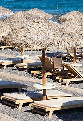 Image showing beach with umbrellas and deck chairs by the sea in Santorini