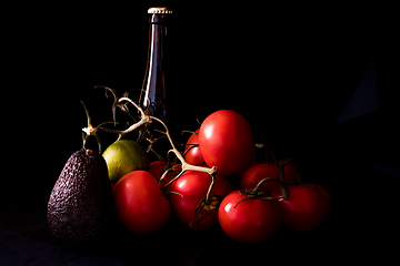 Image showing large red and ripe tomatoes with lime avocado and bottle of beer