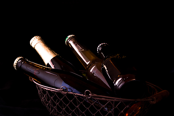 Image showing beer bottles on a black background chiaroscuro in an old metal m