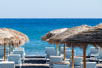 Image showing beach with umbrellas and deck chairs by the sea in Santorini