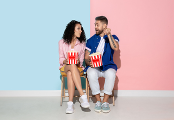 Image showing Young emotional man and woman on pink and blue background