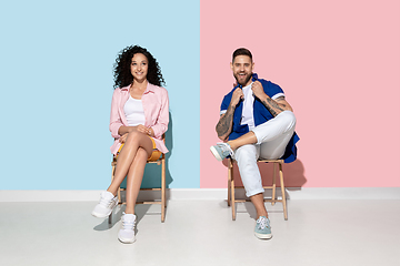 Image showing Young emotional man and woman on pink and blue background