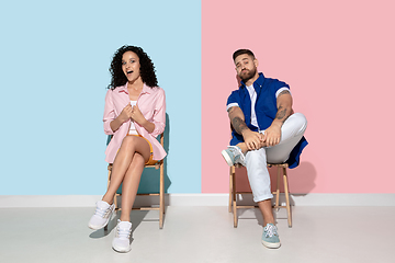 Image showing Young emotional man and woman on pink and blue background