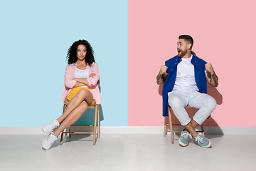 Image showing Young emotional man and woman on pink and blue background