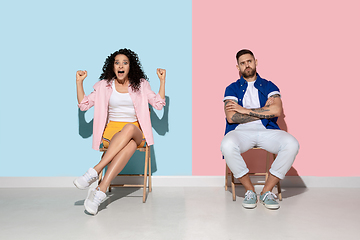 Image showing Young emotional man and woman on pink and blue background