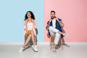 Image showing Young emotional man and woman on pink and blue background