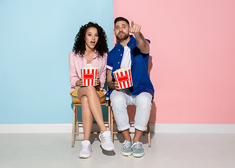 Image showing Young emotional man and woman on pink and blue background