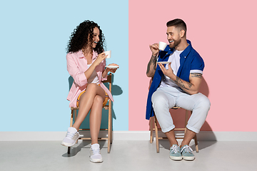 Image showing Young emotional man and woman on pink and blue background