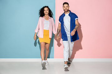 Image showing Young emotional man and woman on pink and blue background