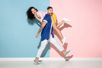 Image showing Young emotional man and woman on pink and blue background