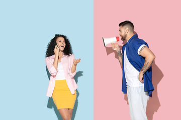 Image showing Young emotional man and woman on pink and blue background