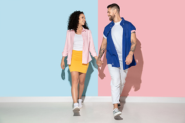 Image showing Young emotional man and woman on pink and blue background