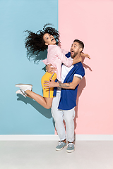 Image showing Young emotional man and woman on pink and blue background