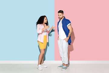 Image showing Young emotional man and woman on pink and blue background