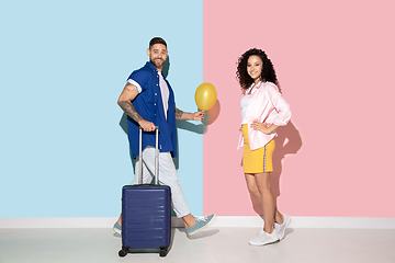 Image showing Young emotional man and woman on pink and blue background