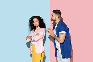 Image showing Young emotional man and woman on pink and blue background