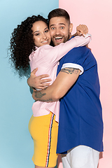 Image showing Young emotional man and woman on pink and blue background