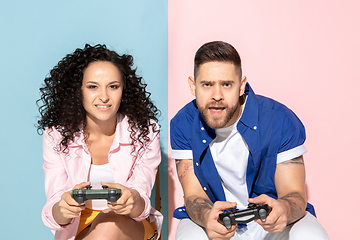 Image showing Young emotional man and woman on pink and blue background