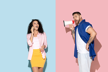 Image showing Young emotional man and woman on pink and blue background