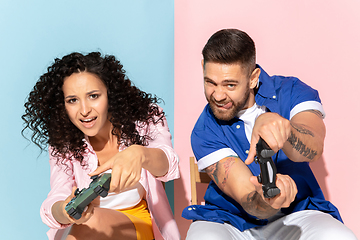 Image showing Young emotional man and woman on pink and blue background