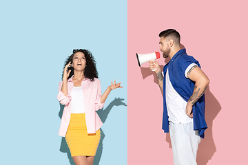 Image showing Young emotional man and woman on pink and blue background