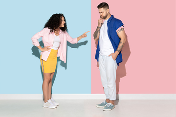 Image showing Young emotional man and woman on pink and blue background