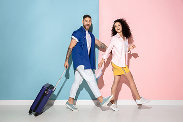 Image showing Young emotional man and woman on pink and blue background